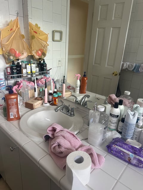 Bathroom counter with sink, toiletries, and pink towel — Yohandra’s Clearning Services, Miami