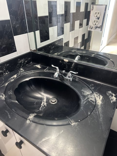 Bathroom sink with black marble counter and chrome faucet — Yohandra’s Clearning Services, Miami