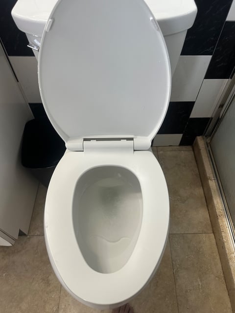 White toilet with open lid in a tiled bathroom — Yohandra’s Clearning Services, Miami